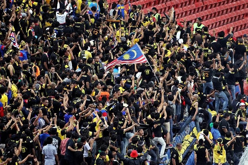 Malaysian football fans cheering during the Asean Football Federation (AFF) Suzuki Cup match between Malaysia and Laos on 28 Nov 2012.&nbsp;Malaysia's Youth and Sports Minister Khairy Jamaluddin has raised questions over the Singapore authorities' al