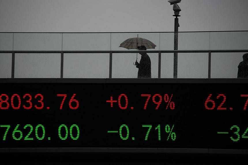 People wake on a bridge with a board showing the numbers of worlds stock exchange rates in the Lujiazui Financial District of Shanghai on Nov 25, 2014.&nbsp;Shanghai's stock index reached a multi-year high on Tuesday as investors remained optimistic 
