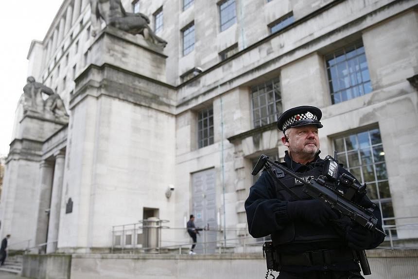 An armed police officer stands on duty outside a government building in Westminster, central London on Nov 24, 2014.&nbsp;Britain will increase spending on its security services to try to prevent so-called 'lone-wolf' attacks against the country, Pri