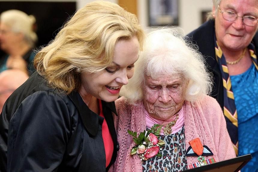 New Zealand's member of parliament Judith Collins (left) and Phyllis Latour Doyle look at the Knight of the national Order of the Legion of Honour award she received from French Ambassador to New Zealand Laurent Contini in Auckland on Nov 25, 2014.&n
