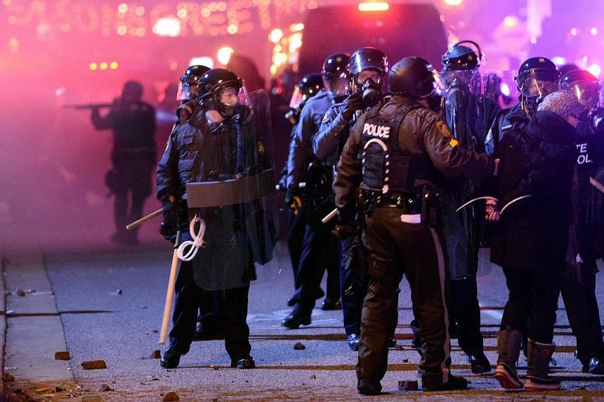 Police detain a protester during clashes over the decision in the shooting of 18-year-old Michael Brown in Ferguson, Missouri, on Nov 24, 2014. -- PHOTO: AFP