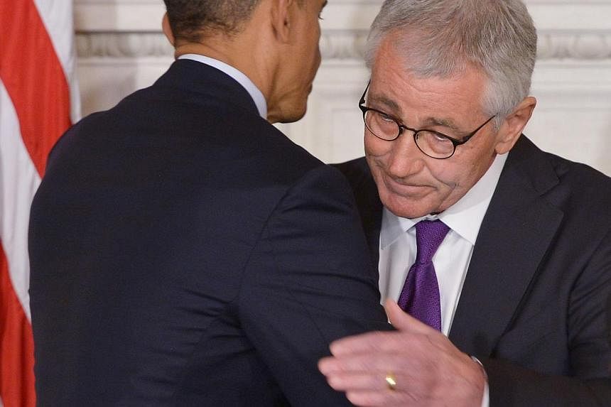 US President Barack Obama and Defence Secretary Chuck Hagel embrace during a press conference to announce Hagel's departure at the White House on Nov 24, 2014 in Washington, DC. Hagel will remain at his post until a successor is named and confirmed b