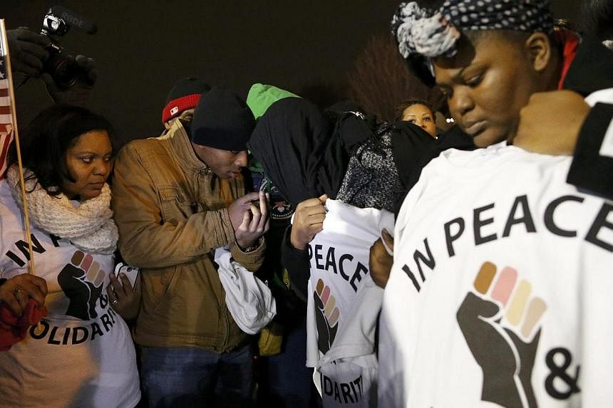 Protesters listen to the grand jury announcement in the shooting of Michael Brown outside the Ferguson Police Department in Ferguson, Missouri on Nov 24, 2014. -- PHOTO: REUTERS
