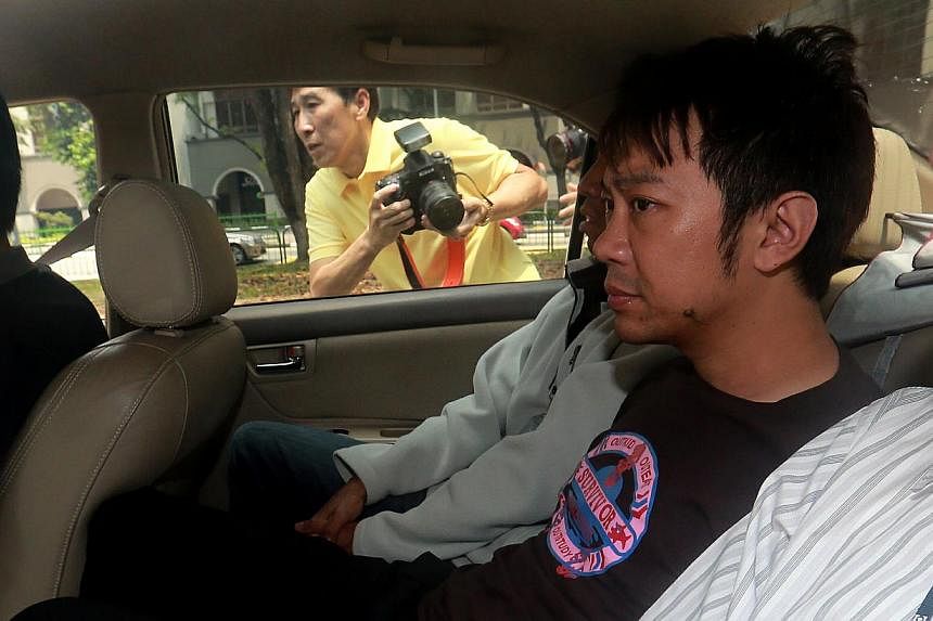 Yang Yin is seen in a police car on Nov 5, 2014. The former China tour guide, accused of manipulating a wealthy widow into making himself her guardian for his personal gain, no longer has any say over her welfare and finances. -- ST PHOTO: WONG KWAI 