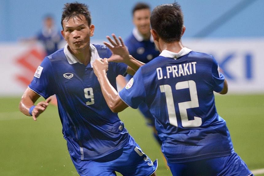 Thailand's Adisak Kraisorn (left) celebrates his goal against Malaysia with teammate Prakit Deeprom in their AFF Suzuki Cup at the Jalan Besar Stadium on Nov 26, 2014. -- ST PHOTO: LIM SIN THAI