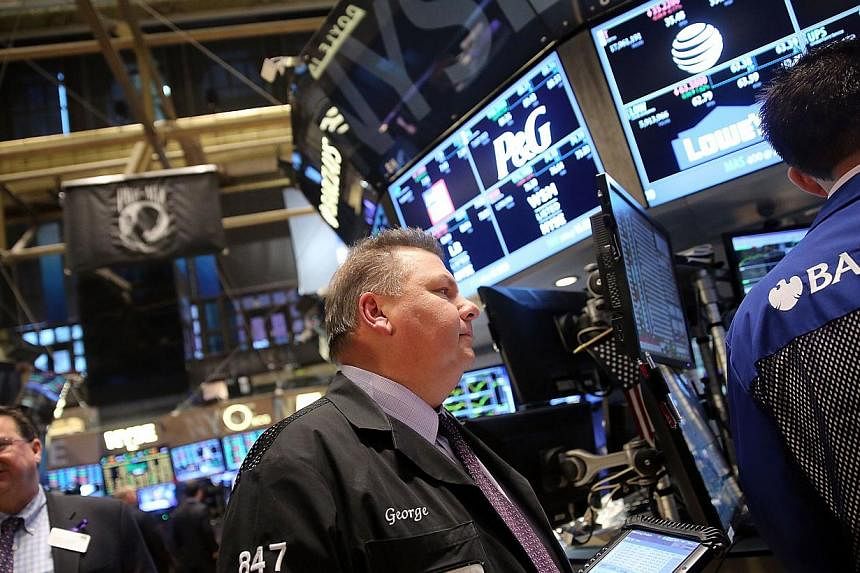 Traders work on the floor of the New York Stock Exchange in New York City on Nov 21, 2014. -- PHOTO: AFP