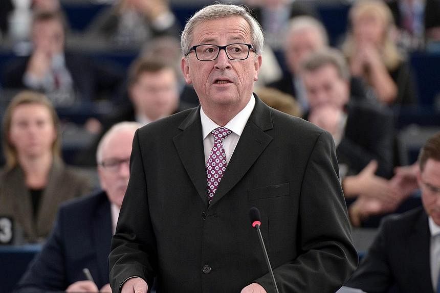 EU Commission chief Jean-Claude Juncker (middle) speaks to unveil an eagerly awaited 315-billion-euro investment plan to "kickstart" the economy, on Nov 26, 2014 at the European Parliament in Strasbourg, eastern France. -- PHOTO: AFP