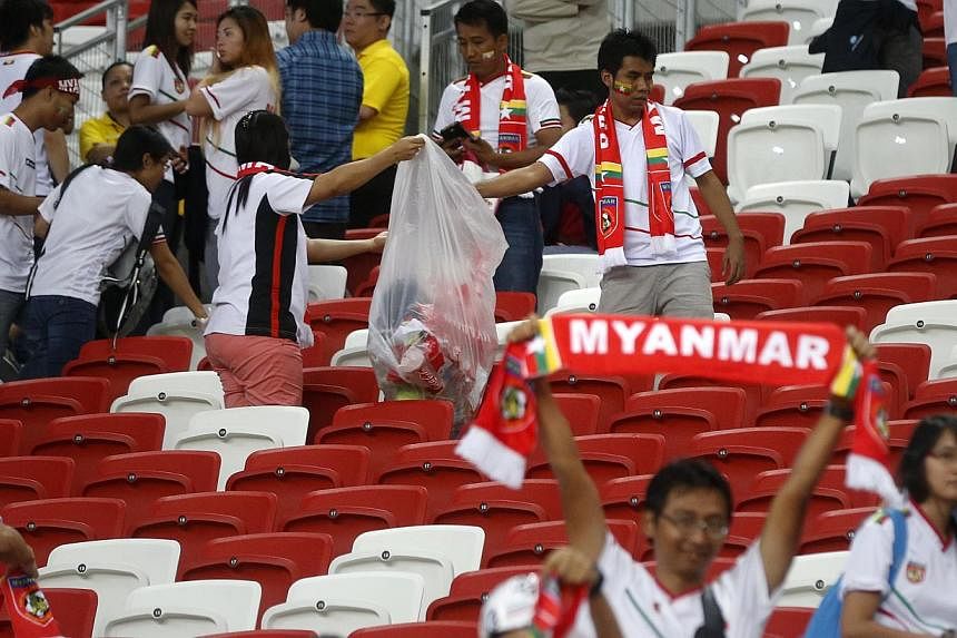 Myanmar fans clearing rubbish from the seats after the match between Singapore and Myanmar in the AFF Suzuki Cup at the National Stadium on Nov 26, 2014. -- ST PHOTO: KEVIN LIM