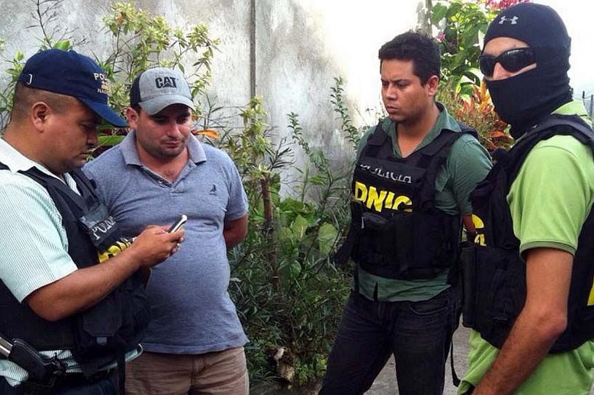National Police agents escort Plutarco Antonio Ruiz (second from left), the boyfriend of Miss Honduras Maria Jose Alvarado's sister, in Santa Barbara, 200km north of Tegucigalpa, on Nov 18, 2014. -- PHOTO: AFP