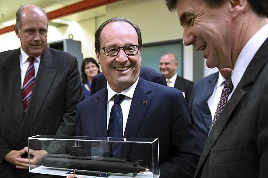 Australia's Defence Minister David Johnston (left) looks on as&nbsp;France's President Francois Hollande (centre inspects a model of the Royal Australian Navy's Collins Class submarine next to and Thales Defence Mission Systems Executive Vice Preside