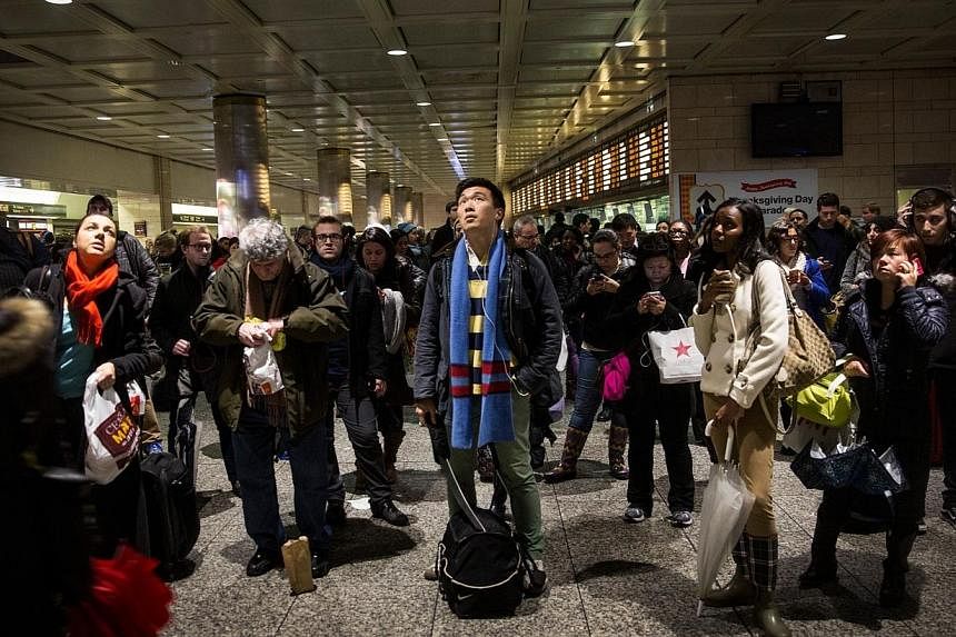 People wait for train information at New York Penn Station during rush hour on the night before Thanksgiving on Nov 26, 2014 in New York City.&nbsp;-- PHOTO: AFP