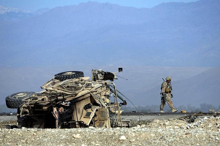 A US soldiers inspects the site of a suicide attack targeting foreign troops in Jalalabad on Nov 13, 2014. Afghanistan's upper house of parliament on Thursday approved two agreements with the US and NATO allowing about 12,500 troops to remain in the 