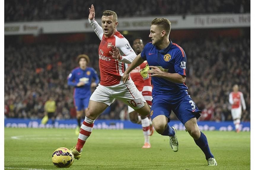 Manchester United's Luke Shaw (right) is challenged Arsenal's Jack Wilshere during their English Premier League soccer match at the Emirates Stadium in London on Nov 22, 2014.&nbsp;Arsenal midfielder Jack Wilshere will be out of action for around thr