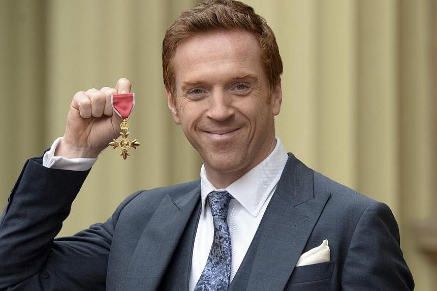 Actor Damian Lewis holds his Officer of the Order of the British Empire (OBE) medal, following an Investiture ceremony at Buckingham Palace in central London Nov 26, 2014. Prince William revealed on Wednesday that he and his wife Kate are fans of hit