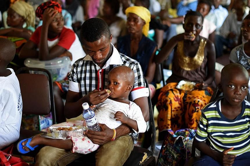 A child who survived the Ebola virus is fed by another survivor at a treatment centre in Sierra Leone on Nov 11, 2014.&nbsp;The death toll in the world's worst Ebola epidemic has risen to 5,689 out of 15,935 cases reported in eight countries by the e