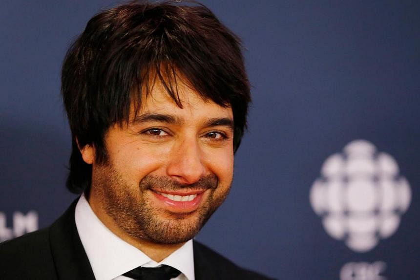 Former syndicated radio host&nbsp;Jian Ghomeshi arrives on the red carpet at the 2014 Canadian Screen awards in Toronto in this file photo from March 9, 2014. Ghomeshi, at the heart of one of Canada's biggest sex scandals, has been charged with sexua