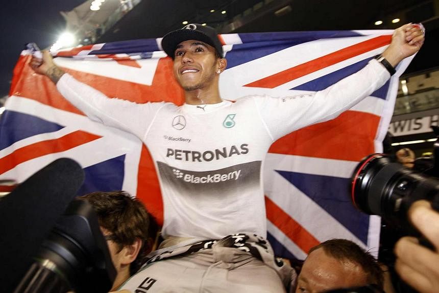 World champion Formula One driver Lewis Hamilton of Britain celebrates his title success in Abu Dhabi on Nov 23, 2014. The controversial "double points" system in the final Formula One Grand Prix of the season will be abandoned next year, British mag