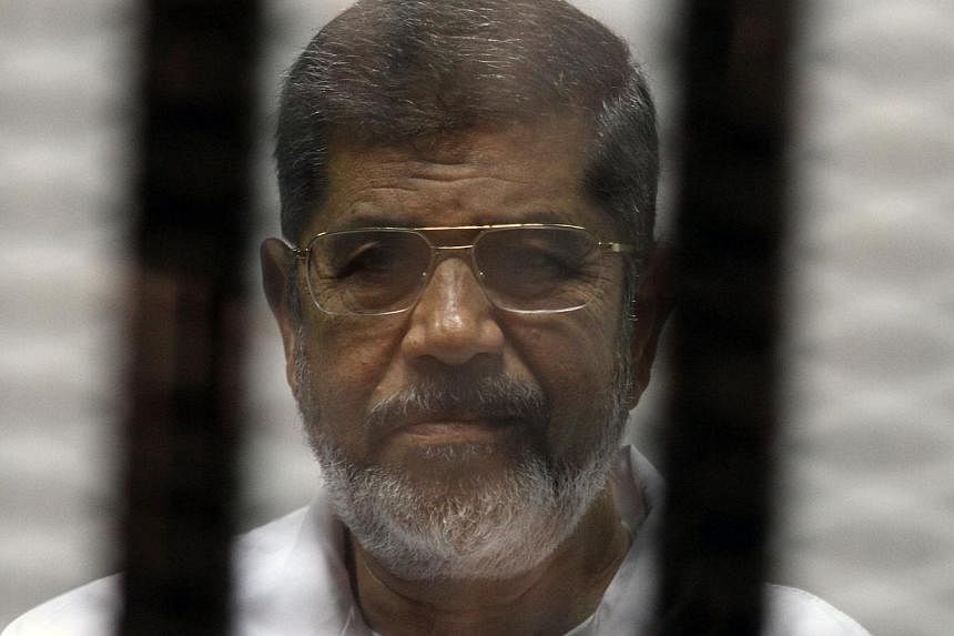 A file picture from May 2014 shows ousted Islamist president Mohamed Morsi looking on from the defendants cage during his trial alongside 130 others on charges of organising jail breaks during the 2011 uprising that toppled strongman Hosni Mubarak. -