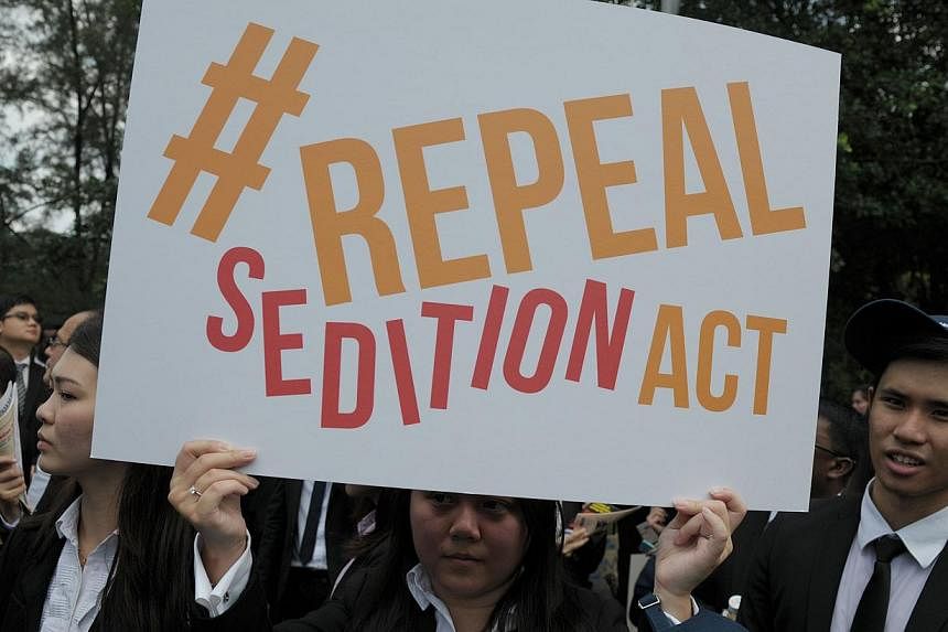 In a photo taken on Oct 16, 2014, a Malaysian Lawyer holds a placard outside Parliament house during a rally to repeal the Sedition Act in Kuala Lumpur. -- PHOTO: AFP