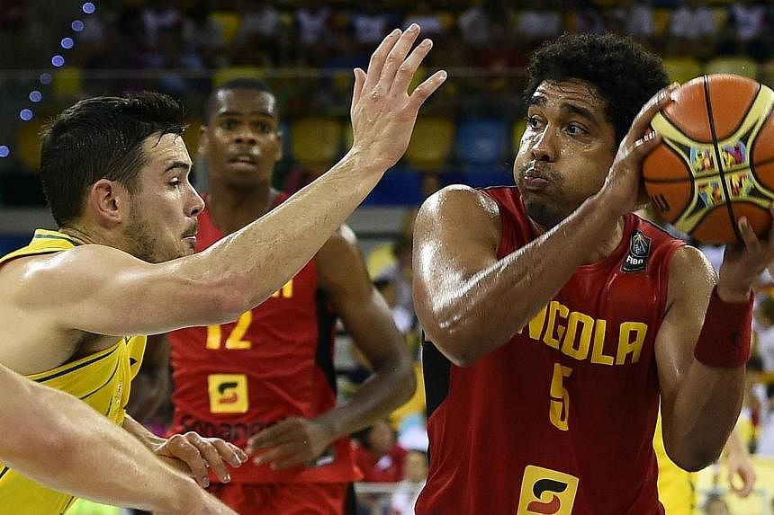Australia's guard Chris Goulding (left) vies with Angola's guard Armando Costa during the 2014 FIBA World basketball championships on Sept 4, 2014. Australia have been cleared of throwing a World Cup match against Angola, the International Basketball