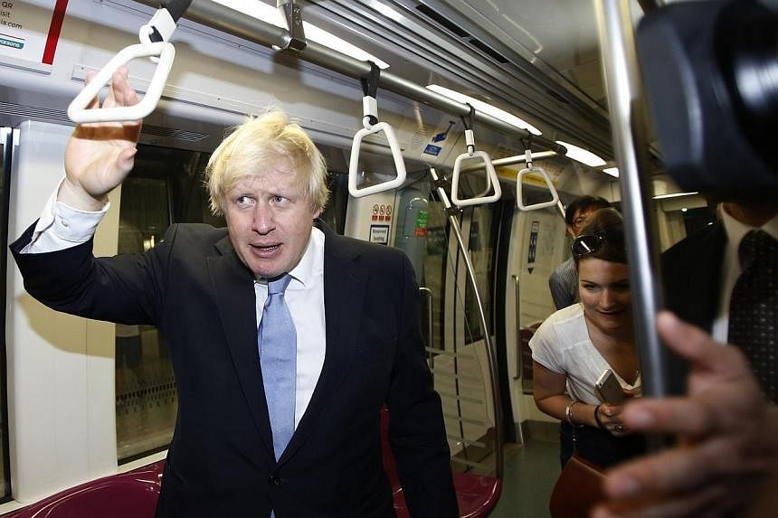 Mayor of London Boris Johnson finds a seat on the train at Bayfront Mass Rapid Transit (MRT) station during his visit in Singapore on Nov 28, 2014. -- PHOTO: REUTERS