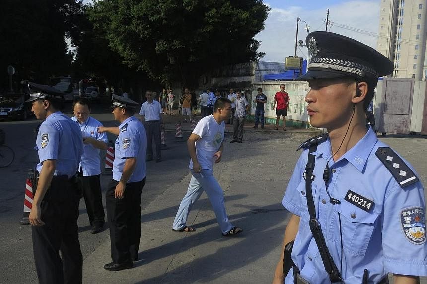 Police officers stand guard outside the court house, blocking roads to the Guangzhou People’s Court in the southern Chinese city of Guangzhou on Sept 12, 2014.&nbsp;The long-awaited trial of a prominent Chinese writer and activist resumed in southe