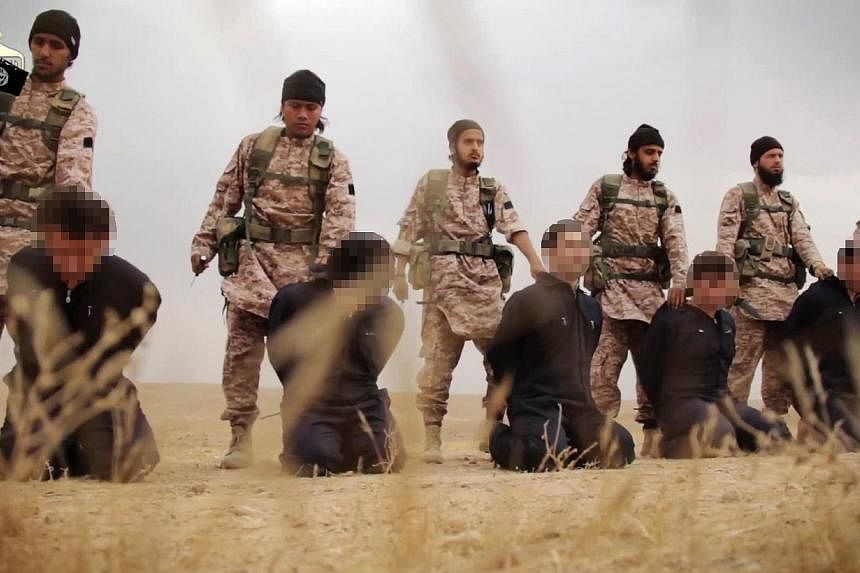 An image grab taken from a propaganda video released on Nov 16, 2014, by al-Furqan Media allegedly shows members of the Islamic State jihadist group preparing the simultaneous beheadings of at least 15 men described as Syrian military personnel.&nbsp