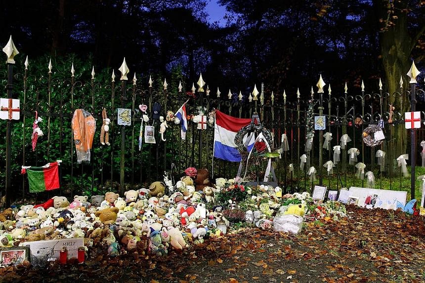 A picture taken on Nov 28 2014, shows flowers and stuffed animals layed outside the Van Oudheusdenkazerne military barracks in Hilversum.&nbsp;Six more coffins holding remains of the victims from downed Malaysia Airlines flight MH17 were on Friday fl