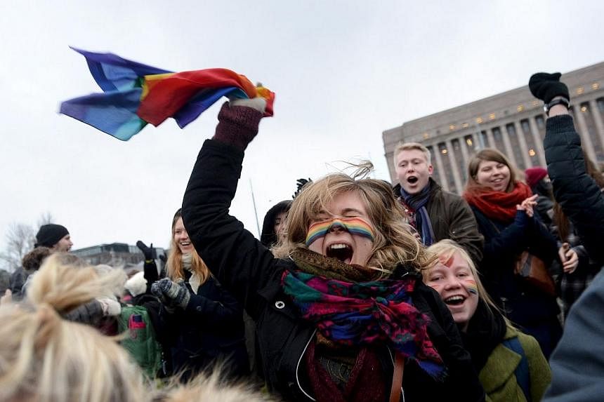 Supporters of same-sex marriage celebrate outside the Finnish Parliament in Helsinki on Nov 28, 2014.&nbsp;The Finnish Parliament on Friday narrowly approved a citizen's initiative to legalise same-sex marriage. -- PHOTO: REUTERS