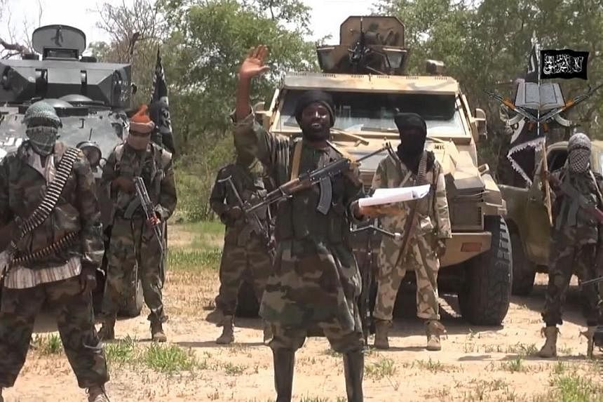 A screengrab taken on July 13, 2014 from a video released by the Nigerian Islamist extremist group Boko Haram and obtained by AFP shows the leader of the Nigerian Islamist extremist group Boko Haram, Abubakar Shekau (centre).&nbsp;Up to 50 people wer