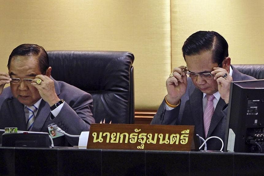 Thailand's Prime Minister Prayuth Chan-ocha (right) and Deputy Prime Minister and Defence Minister Prawit Wongsuwan don glasses before Prayuth reads out his government's policy, at the Parliament in Bangkok on Sept 12, 2014.&nbsp;Thailand's deputy pr