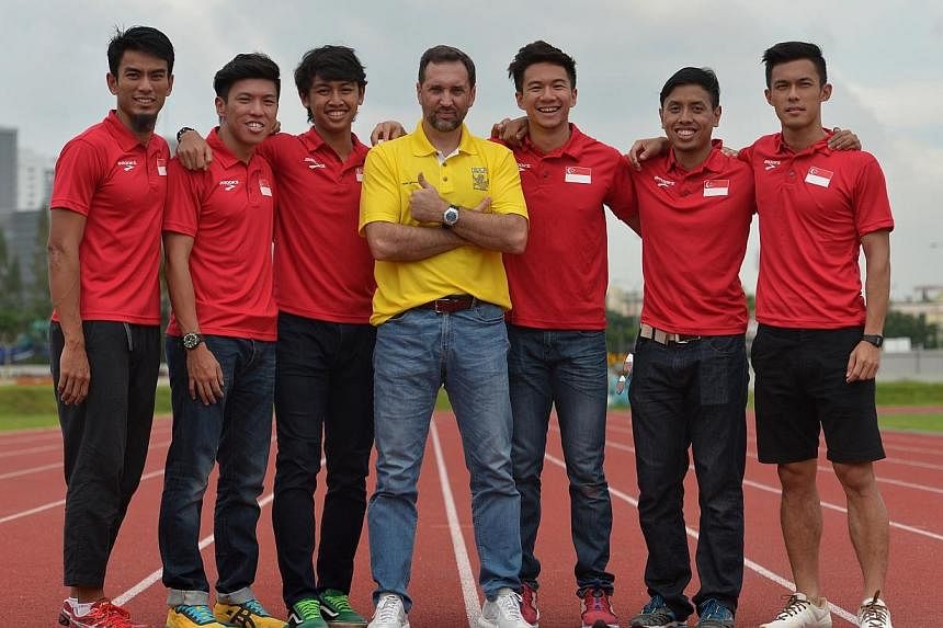 The new Singapore Athletic Association head coach for sprints and hurdles, Mr Luis Cunha (centre), with the Singapore 4x100 team on Nov 28, 2014. -- ST PHOTO: CAROLINE CHIA