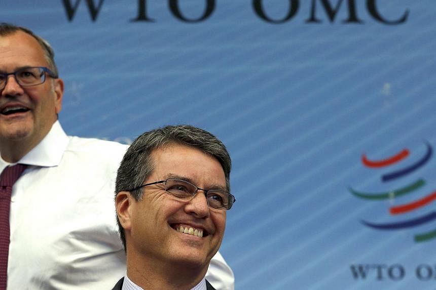 World Trade Organisation director-general Roberto Azevedo (right) smiles next to spokesman Keith Rockwell at the WTO meeting in Geneva Nov 27, 2014. The World Trade Organisation adopted the first worldwide trade reform in its history on Thursday, aft