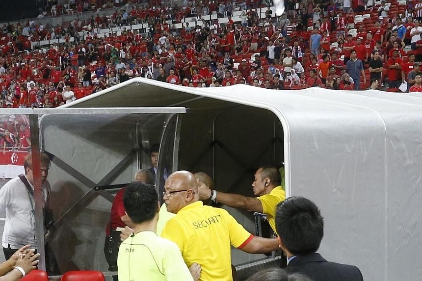 Referees leaving the field at the AFF Suzuki Cup's Singapore v Malaysia match at the National Stadium on Nov 29, 2014. -- ST PHOTO: KEVIN LIM