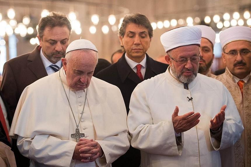 In this handout picture released by the Vatican press office Pope Francis (left) visits the Blue Mosque (Sultan Ahmet mosque) with Mufti Rahmi Yaran on Nov 29, 2014 in Istanbul.&nbsp;Pope Francis prayed silently alongside a senior Islamic cleric in I