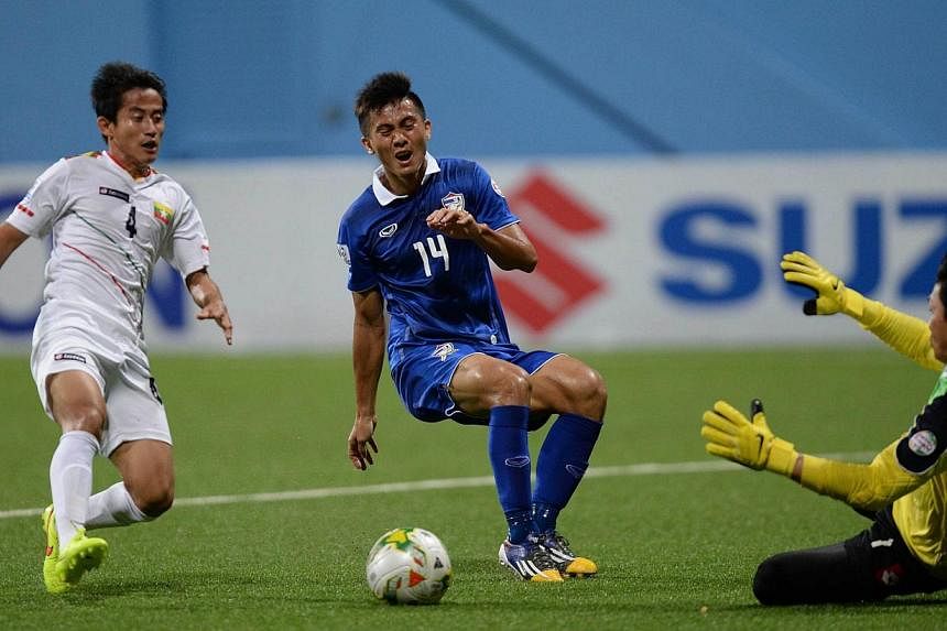 Thailand's Sarawut Masuk (centre) makes an attempt at goal during the AFF Suzuki 2014 Cup football match between Thailand and Myanmar at the Jalan Besar Stadium in Singapore on Nov 29, 2014.&nbsp;Thailand will face the Philippines in the AFF Suzuki C