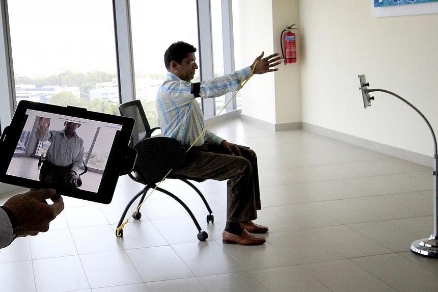 A hospital staff member demonstrating a therapy session conducted via video. Sensors are attached to the body parts that patients exercise. Adaptive design is about designing interfaces that adapt to different user profiles.