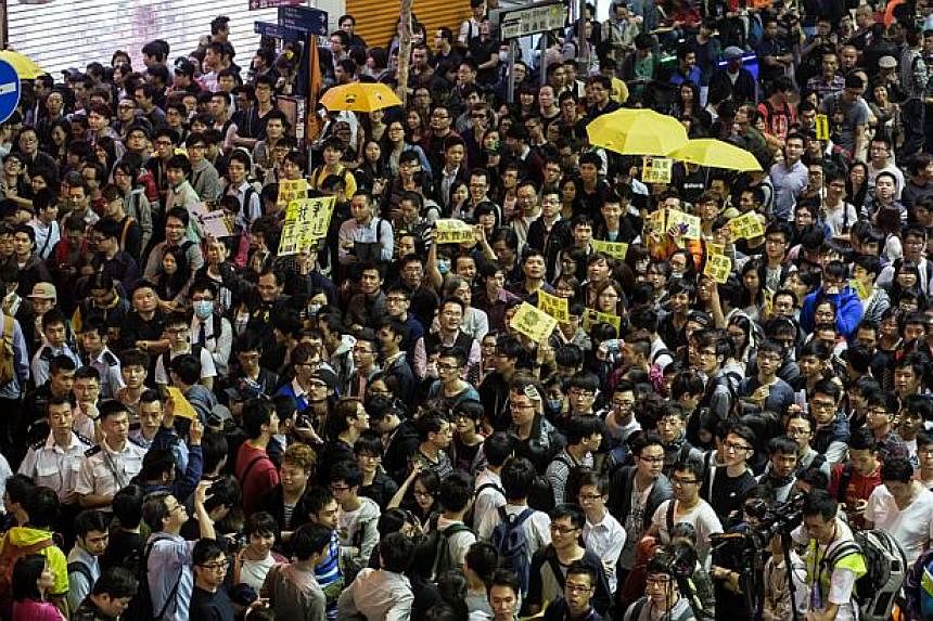 Pro-democracy protesters shout slogans as they gather in a street in the Mongkok district of Hong Kong on Nov 28, 2014. Amnesty International on Nov 28 warned Hong Kong police against "excessive force" ahead of a planned rally by pro-democracy demons