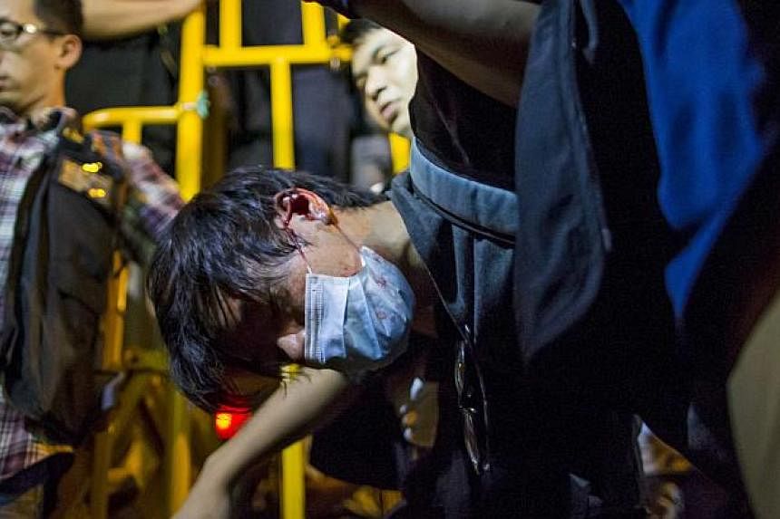 A pro-democracy protester is detained by police during a confrontation at Mongkok shopping district in Hong Kong early Nov 29, 2014. -- PHOTO: REUTERS