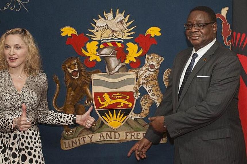 US pop star Madonna poses with Malawi's president Peter Mutharika prior to their meeting at Kamuzu Palace in the Capital Lilongwe, on Nov 28, 2014.&nbsp;Madonna met Malawi's new president on Friday after her VIP status was restored in the country whe