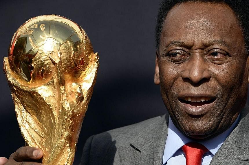 Brazilian football legend Pele poses with the Fifa Football World Cup trophy on March 9, 2014 in Paris.&nbsp;Pele's health is improving, but he is still receiving an intensive kidney treatment for a urinary infection, the hospital treating him said F