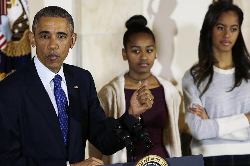 US President Barack Obama speaking at the annual Thanksgiving turkey "pardon", along with daughters Sasha and Malia (right), both of whom looked underwhelmed during the occasion. -- PHOTO: REUTERS
