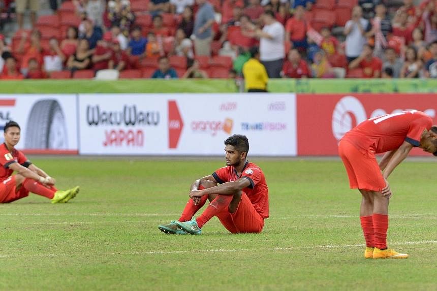 Dejected Singapore players (from left)&nbsp;&nbsp;Shahril Ishak, Hariss Harun and Faris Ramli on the pitch after their 3-1 loss to bitter rivals Malaysia in their AFF Suzuki Cup match at the National Stadium on Nov 29, 2014. -- ST PHOTO: LIM SIN THAI