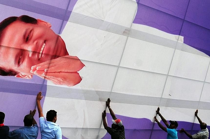 Sri Lankan opposition party workers erect a cutout of their presidential candidate Maithripala Sirisena in the north central town of Polonnaruwa on Nov 30, 2014.&nbsp;Sri Lanka's opposition parties formally launched their bid Sunday to topple long-se