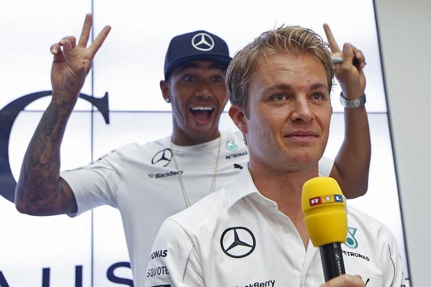 Mercedes Formula One driver Lewis Hamilton of Britain gesturing to fans as he passes teammate Nico Rosberg of Germany during interviews in Singapore on Sept 17, 2014. Lewis Hamilton said Saturday the tension with his Mercedes team-mate Nico Rosberg h