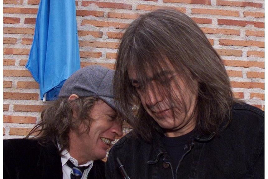 This file photo taken on March 22, 2000 shows Australian guitarists and brothers Angus (left) and Malcom Young (right) of the hard rock group AC/DC inaugurating a street named after them in Leganes, near Madrid in Spain. Angus Young said he first not