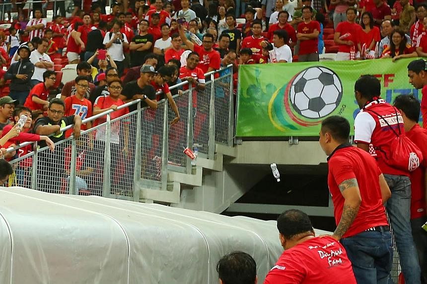 Singapore supporters hurling water bottles at the tunnel as the Malaysian players departed the pitch after their 3-1 AFF Suzuki Cup win over the Lions at the National Stadium on Nov 29, 2014. -- PHOTO: TNP&nbsp;