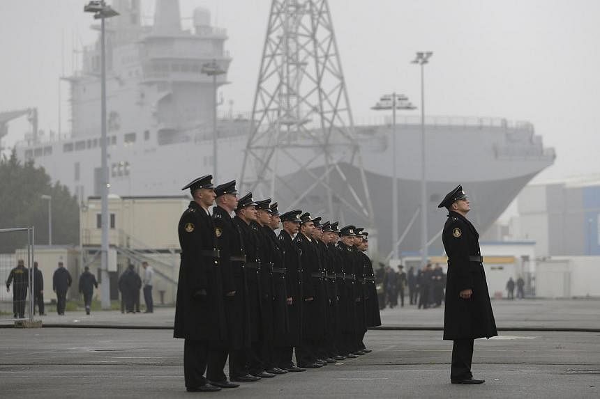 Russian sailors stand in formation in front of the Mistral-class helicopter carrier Vladivostok at the STX Les Chantiers de l'Atlantique shipyard site in Saint-Nazaire, western France, onNov 25, 2014.&nbsp;Russia said on Dec 1, 2014, that it would ca