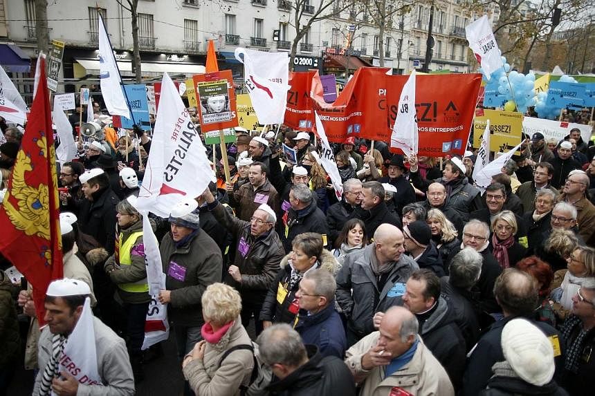 Heads of small and mid-size French companies hold banners as they attend a demonstration organized by the French CGPME (Confederation of Small and Medium Sized Enterprises) employers groups to protest against government policy and what they see as ex