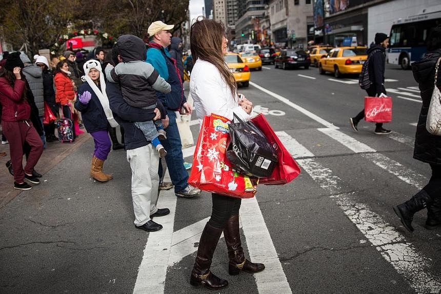 Shoppers carry recent purchases through Herald Square on the morning of Nov 28, 2014 in New York City. Consumer spending during America's Thanksgiving weekend dropped compared to last year, but the decline can be attributed to an improving economy an